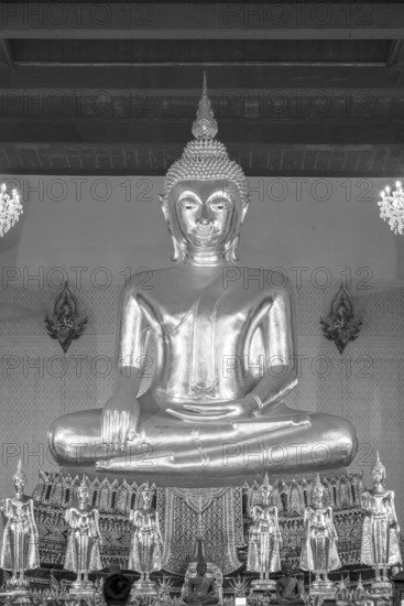 Buddha statue with Bhumispara mudra, Buddha Gautama at the moment of enlightenment, in front of it several small standing Buddha statues with the Abhaya Mudra for protection and fearlessness, Wat Prayurawongsawas Waravihan, also: Wat Prayun, Bangkok, Thailand