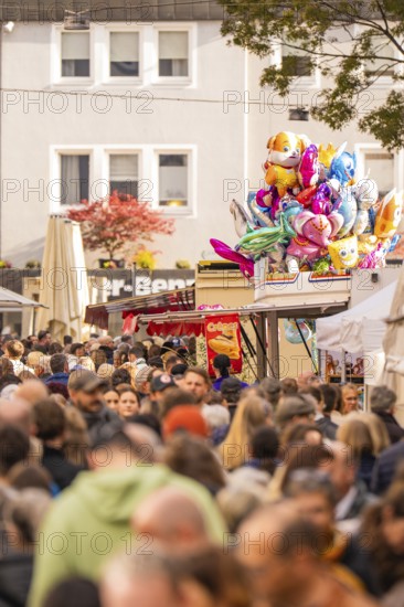 Busy shopping street in autumn, people strolling between modern buildings and colorful shops, Urschelherbst street festival, Nagold, Germany