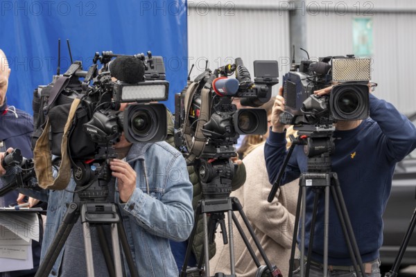 Camera crews, TV teams from various radio stations, television stations, film at a press conference