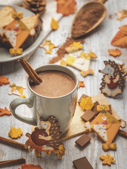 Cup of hot chocolate with cinnamon stick and autumn animal decorations