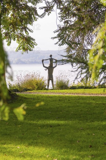 A statue in a park surrounded by trees and green grass with an autumnal atmosphere, Überlingen, Lake Constance, Germany
