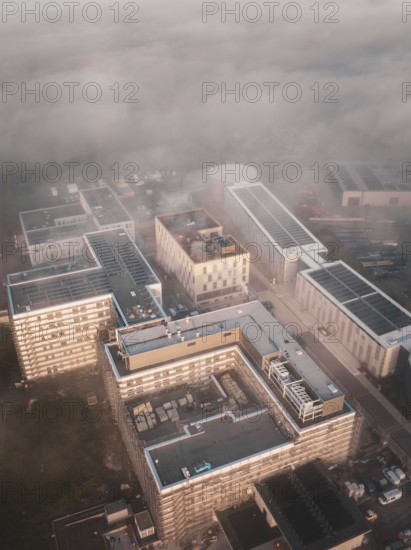 Urban industrial area seen from above in fog and dawn, new hospital health campus building, Calw, Germany