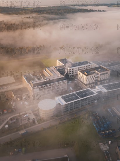 Industrial complex and natural environment shrouded in thick fog, new hospital health campus building, Calw, Germany