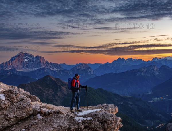 Mountaineers in front of rugged Dolomite peaks in the evening light, Dolomites, Alps, Belluno province, Veneto region, Italy