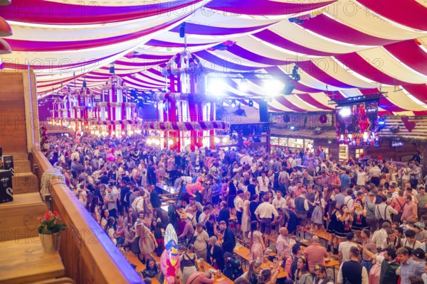 Fully occupied marquee with people in traditional costumes and colourful decorations, Cannstatter Wasen folk festival, Sonja Merz marquee, Stuttgart, Germany