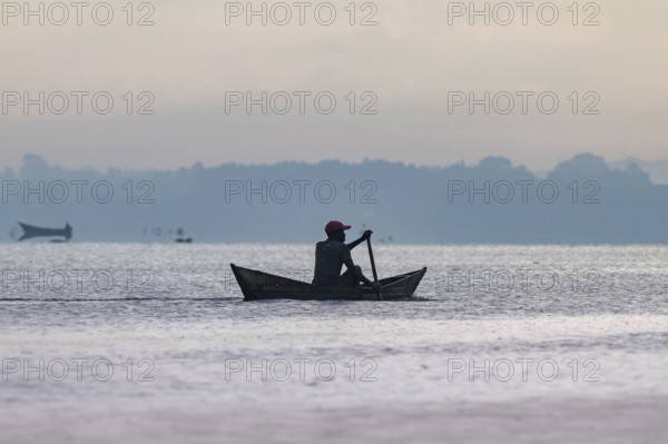 Fisherman in a rowing boat, silhouette, morning mood, Mabamba Swamp, Lake Victoria, Uganda
