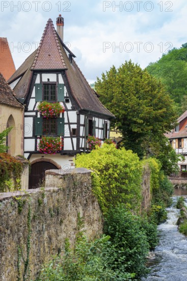 Picturesque Kaysersberg with half-timbered houses on the Weiss river in the old town centre