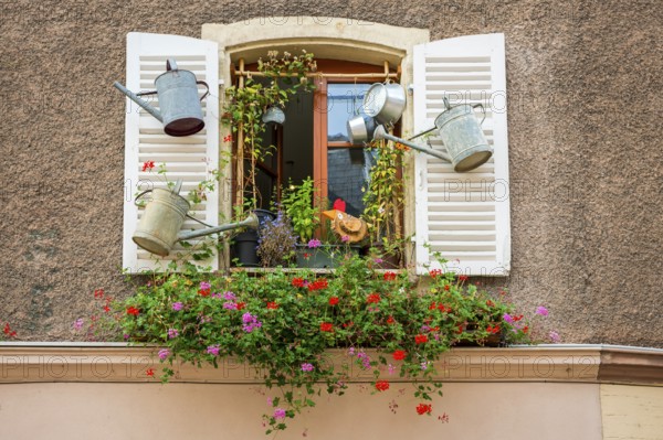 Decorated window with watering cans in Ribeauvillè