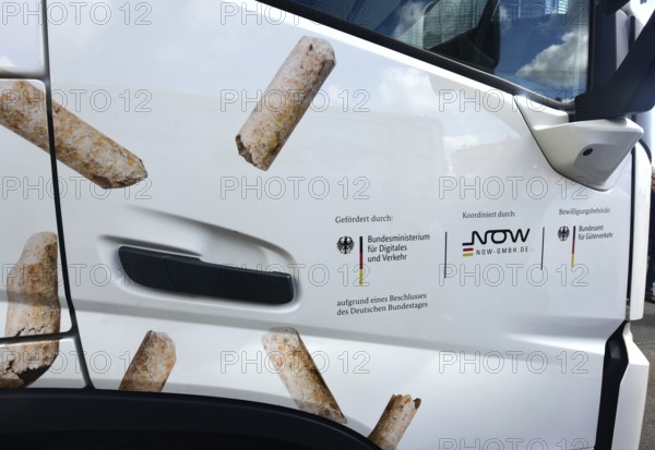 The passenger door of an electric lorry shows which state institutions have paid and approved subsidies. The vehicle is parked on the premises of the Enegie-Mann company in Westerwald