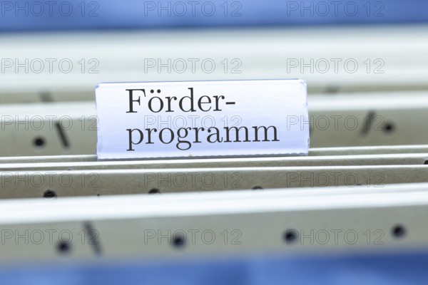 (Photomontage) Sign with the inscription FÖRDERPROGRAMM on a hanging folder index