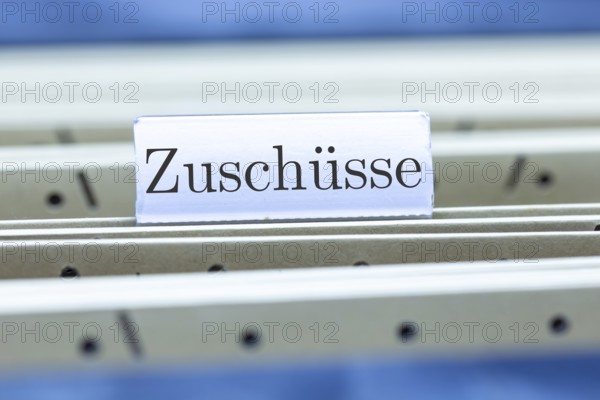 (Photomontage) Sign with the inscription ZUSCHÜSSE on a suspension file index