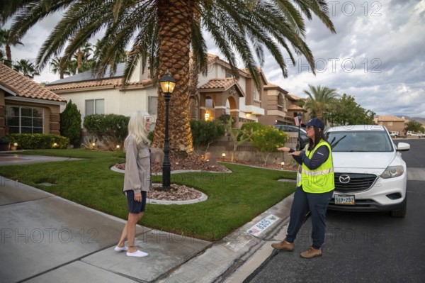 Las Vegas, Nevada - Devyn Choltko, a water waste investigator, talks to a resident about water use regulations. The Las Vegas Valley Water District has cut usage of scarce Colorado River water by more than 30% over the last 20 years despite a growing population