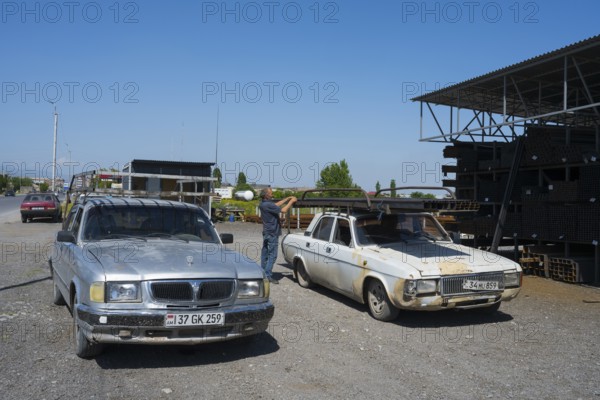 Two rusty old cars, a man in the background, mid-range cars GAZ-3110 Volga and GAZ-24 Volga, Norapat, Armavir province, Armenia