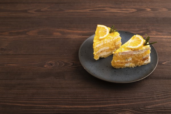 Lemon cake on brown wooden background, side view, copy space