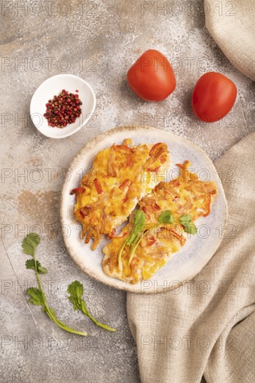 Baked chicken meat with cheese and tomatoes on brown concrete background and linen textile. top view, flat lay, close up