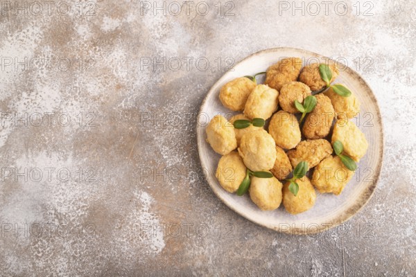 Fried crispy Chicken Nuggets with ketchup, microgreen on brown concrete background. top view, flat lay, copy space