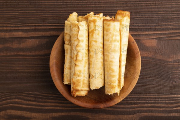 Waffles with caramel on brown wooden background, top view, flat lay, copy space