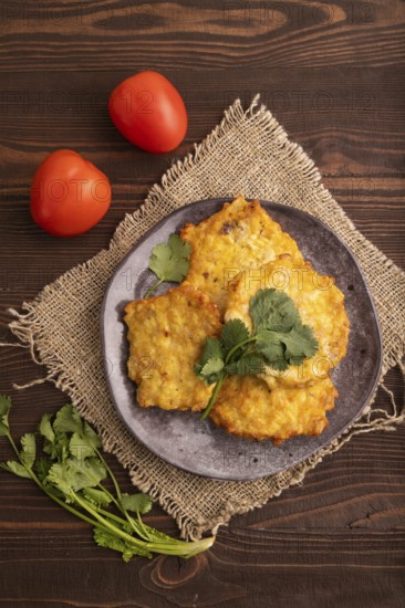 Fried crispy Chicken pancakes on brown wooden background and linen textile. top view, flat lay, close up