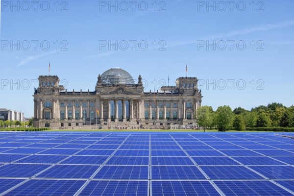 Symbolic image, solar park in the city, Reichstag building Berlin with modules on the green area, fictitious example photo, sensible use of space, renewable energy, green energy, hydropower, wind power, solar energy, solar power, photovoltaics, climate change, climate protection, CO2 emissions, ecology, greenhouse gases, Germany