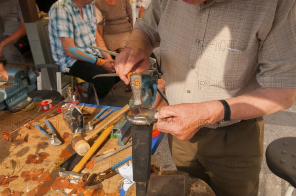Tinsmith at work, old trade, tinsmiths or plumbers are craftsmen who take care of metal products. City festival, Munich, Bavaria