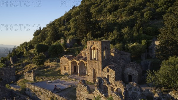 Church of Agia Sophia from the 14th century AD, An ancient church and ruins are bathed in warm evening light on an overgrown hillside, Mystras, Mistra, UNESCO World Heritage Site, Medieval Byzantine ruined city, northwest of Sparta, foothills of the Tyagetos Mountains, Peloponnese, peninsula, Greece