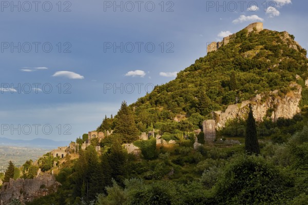 Byzantine Castle of Mystras, Ancient ruins spread on a green hill under a clear blue sky, Mystras, Mistra, UNESCO World Heritage Site, Medieval Byzantine ruined city, northwest of Sparta, foothills of the Tyagetos Mountains, Peloponnese, Peninsula, Greece