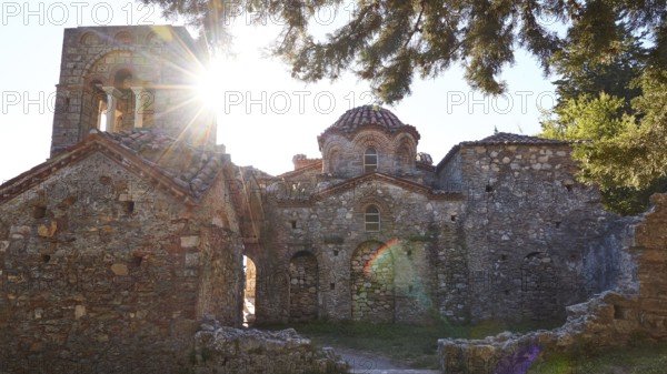 Church of Agia Sophia from the 14th century AD, sunlight shining through the windows of an old church surrounded by trees, Mystras, Mistra, UNESCO World Heritage Site, Medieval Byzantine ruined city, northwest of Sparta, foothills of the Tyagetos Mountains, Peloponnese, peninsula, Greece