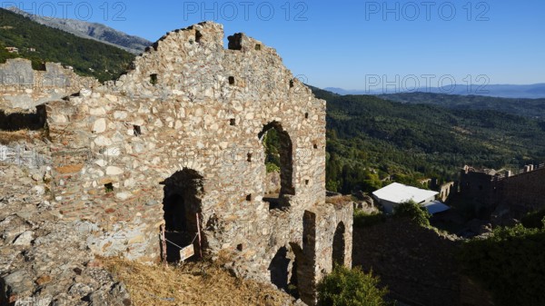 Ruins on a hill overlooking a vast mountain landscape under a clear blue sky, Mystras, Mistra, UNESCO World Heritage Site, Medieval Byzantine ruined city, northwest of Sparta, foothills of the Tyagetos Mountains, Peloponnese, peninsula, Greece