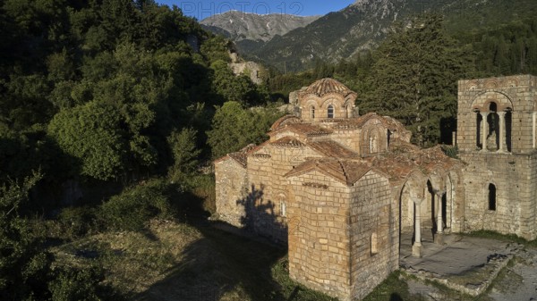 Drone shot, Church of Agia Sophia from the 14th century AD, An old church with ruins in the foreground and mountains in the background in sunshine, Mystras, Mistra, UNESCO World Heritage Site, Medieval Byzantine ruined city, northwest of Sparta, foothills of the Tyagetos Mountains, Peloponnese, peninsula, Greece
