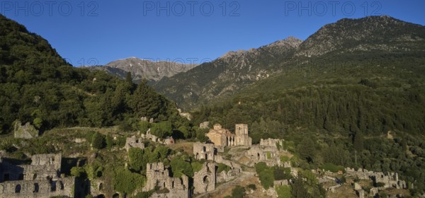 Drone shot, Ancient ruins in a mountainous and wooded environment in sunny weather, including the church of Agia Sophia from the 14th century AD, Mystras, Mistra, UNESCO World Heritage Site, Medieval Byzantine ruined city, northwest of Sparta, foothills of the Tyagetos Mountains, Peloponnese, Peninsula, Greece