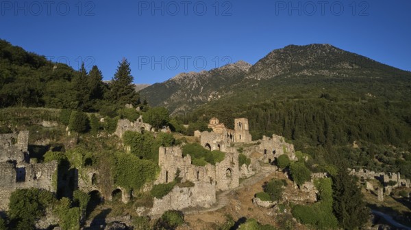 Drone shot, Historical ruins in a hilly landscape with a clear blue sky, Church of Agia Sophia from the 14th century AD, Mystras, Mistra, UNESCO World Heritage Site, Medieval Byzantine ruined city, northwest of Sparta, foothills of the Tyagetos Mountains, Peloponnese, peninsula, Greece
