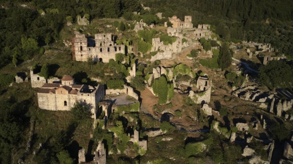 Ancient ruins spread over a hilly landscape with abundant greenery, Mystras, Mistra, UNESCO World Heritage Site, Medieval Byzantine ruined city, northwest of Sparta, foothills of the Tyagetos Mountains, Peloponnese, peninsula, Greece