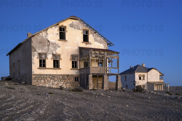 Dilapidated buildings in the desert sand, blue hour, Kolmanskop, near Lüderitz, Karas region, Namibia