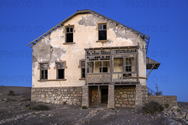 Dilapidated building in the desert sand, blue hour, Kolmanskop, near Lüderitz, Karas region, Namibia