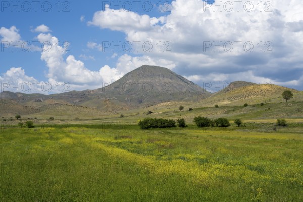 Mountain landscape with vast green and yellow fields under a cloudy sky, landscape near Shaghap, Ararat province, Armenia
