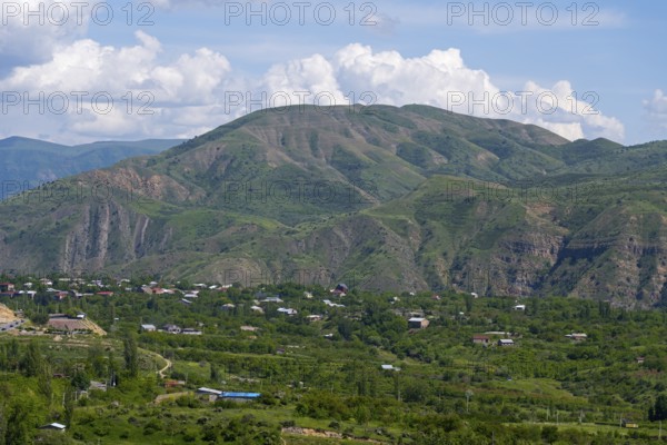 Wide valley with green hills and a few scattered houses under a blue sky, view of Garni, Kotayk province, Armenia