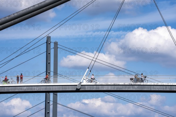 Bridges in Düsseldorf, in the foreground, the pedestrian and cycle bridge over the canal to the inner harbour, media harbour of Düsseldorf, behind it the Rheinkniebrücke, road bridge over the Rhine near Düsseldorf, Germany