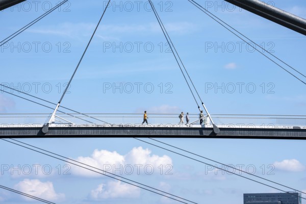 Bridges in Düsseldorf, in the foreground, the pedestrian and cycle bridge over the canal to the inner harbour, media harbour of Düsseldorf, behind it the Rheinkniebrücke, road bridge over the Rhine near Düsseldorf, Germany