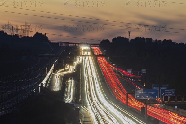 Motorway near Stuttgart with several lanes in the evening with sunset. Heavy traffic with light lanes. BAB 8 motorway near Wendlingen, Baden-Württemberg, Germany