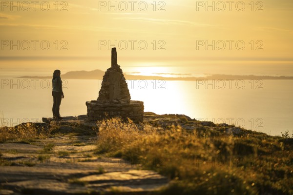 Woman standing next to cairn and looking at the sea, Rørsethornet stone staircase, with 3292 steps one of the longest continuous stone staircases in the world, Sherpat stairs or Midsund stairs or Midsundtrappene, Rørsethornet hike, evening mood, Otroya or Otrøya island, Møre og Romsdal, Norway