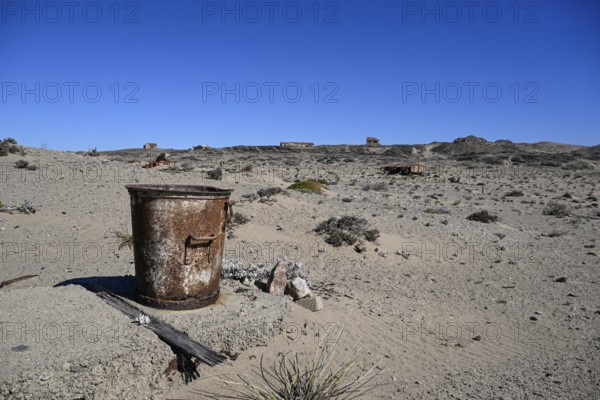 Rusted bucket in the desert sand, Pomona, restricted diamond area, near Lüderitz, Karas region, Namibia