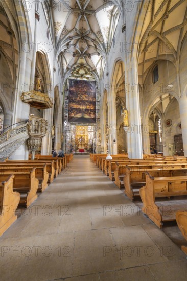 Gothic church with detailed construction, wooden benches and large painted banner above the altar area, St Nicholas Minster, Überlingen, Lake Constance, Germany
