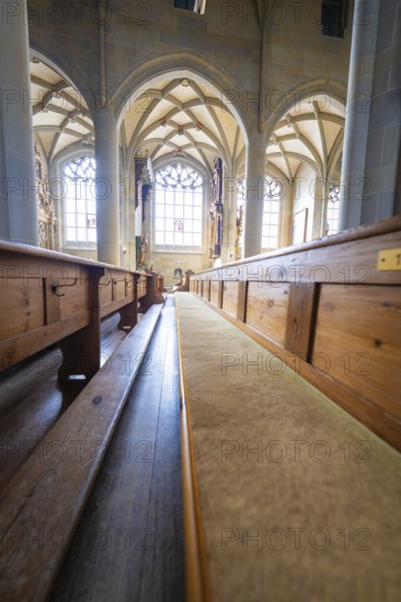 Bright church interior with long wooden benches, Gothic windows and vaulted ceiling, St Nicholas Minster, Überlingen, Lake Constance, Germany