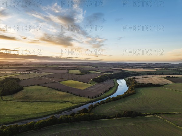 Sunset of Farms and Fields over Norham Castle from a drone, Norham, River Tweed, Northumberland, England, United Kingdom