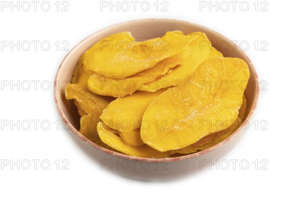 Dried Mango in ceramic bowl isolated on white background. Side view, close up, flat lay. healthy food, minimalism