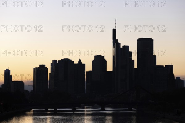 The silhouette of Frankfurt's banking skyline stands out against the backlight of the evening sun, Frankfurt am Main, Hesse, Germany