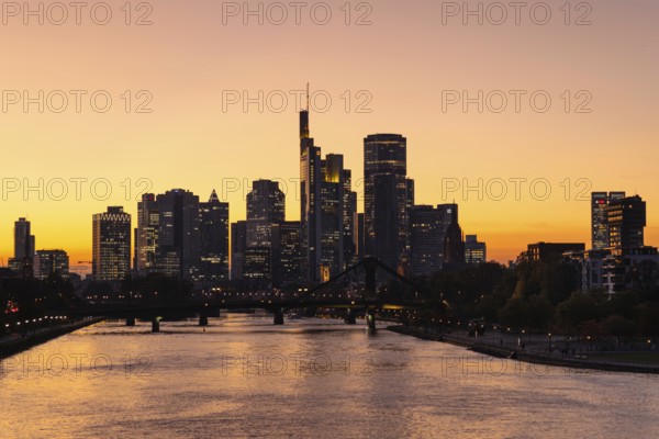 The evening sky behind the Frankfurt banking skyline glows orange and yellow shortly after sunset, Frankfurt am Main, Hesse, Germany