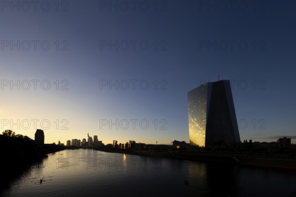 The light of the setting sun is reflected in the glass façade of the Frankfurt banking skyline, Frankfurt am Main, Hesse, Germany