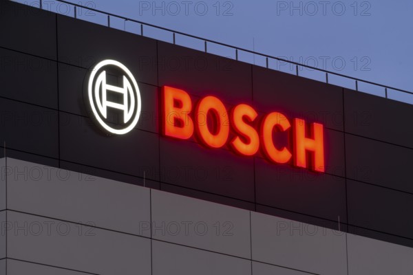 Illuminated Bosch logo on a grey façade against a blue night sky, Waiblingen, Baden-Württemberg, Germany