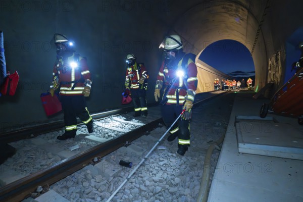 Firefighters walk along tracks in a tunnel at night, firefighting exercise in the new tunnel of the Hermann Hesse railway, Ostelsheim, Calw district, Germany